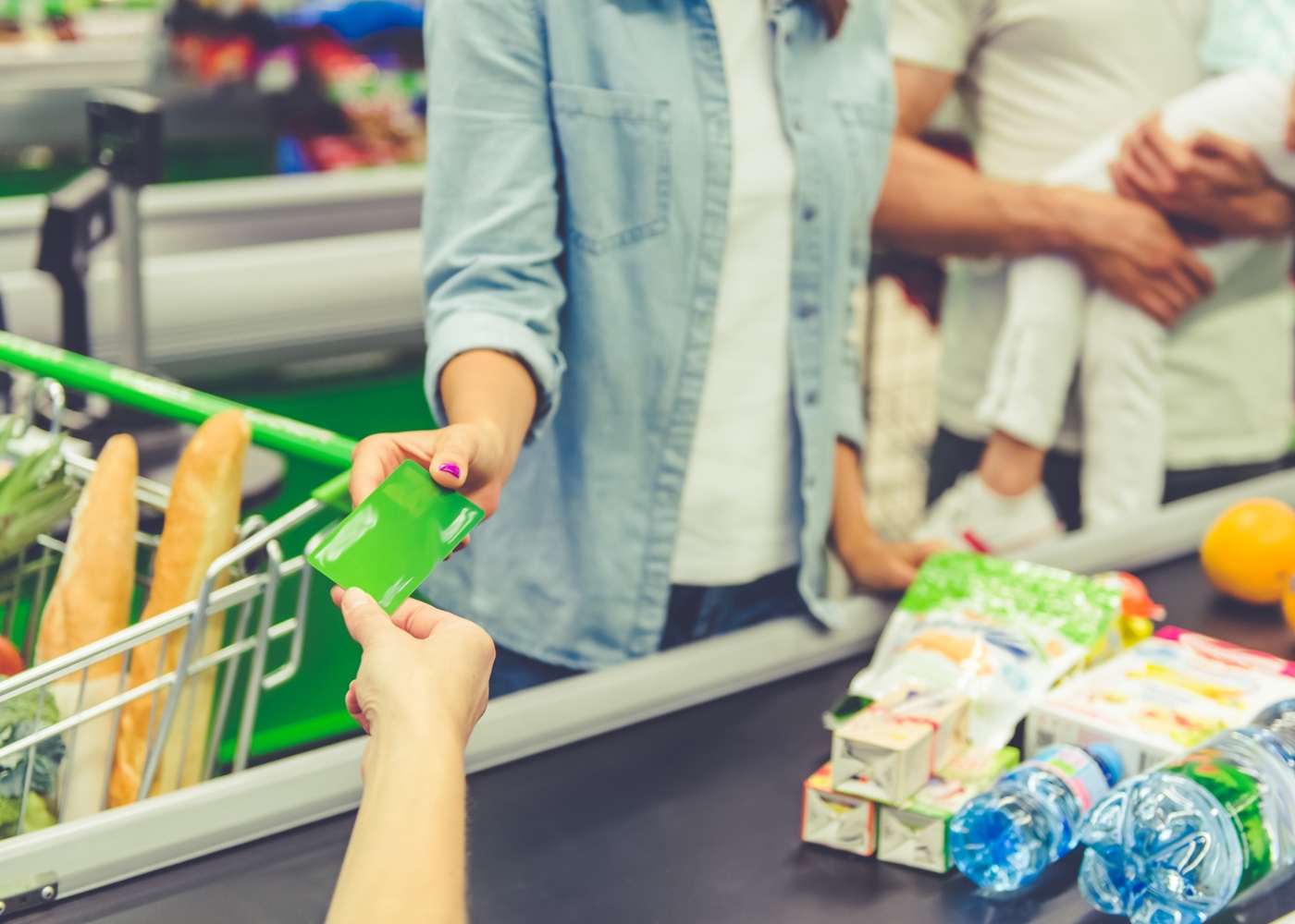 Mulher a utilizar cartão de fidelização na caixa de supermercado