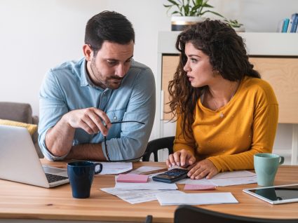 Casal a fazer contas e a analisar o orçamento familiar