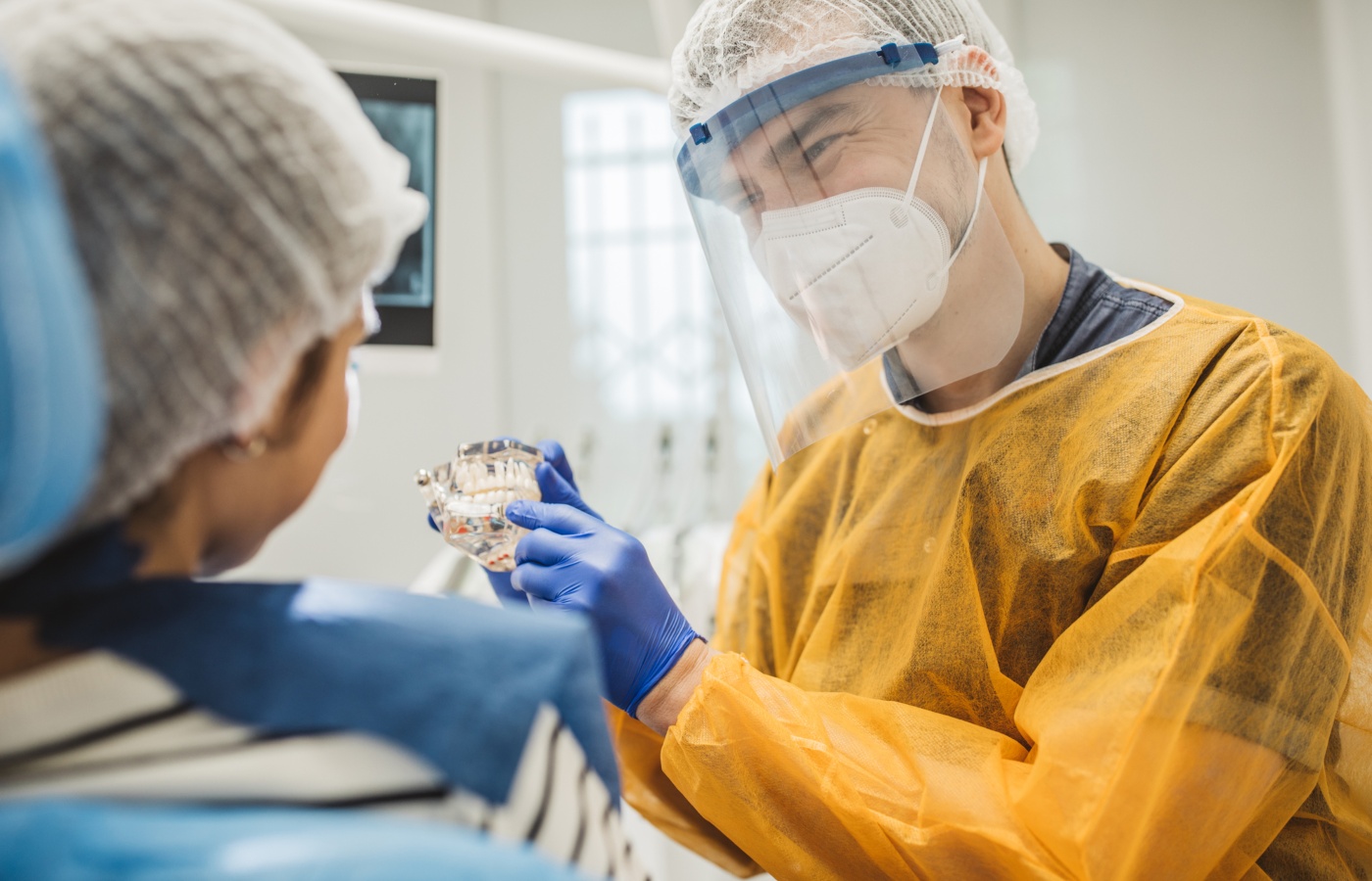 dentista mostra molde de dentição a paciente