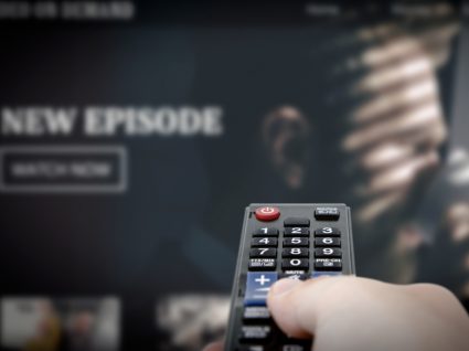 Homem a ver série da Netflix em casa