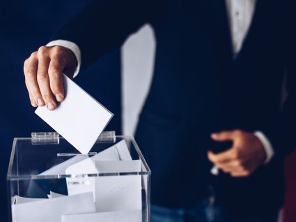 Homem a depositar o seu voto numa urna