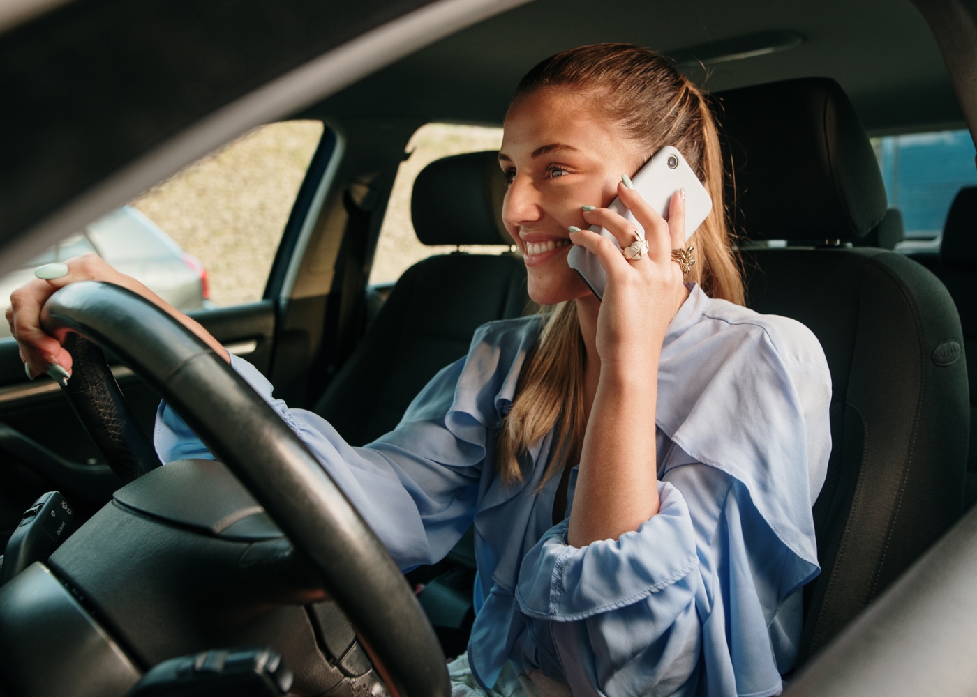 Mulher a conduzir e a falar ao telemóvel