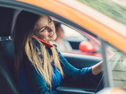 Mulher a falar ao telemóvel enquanto conduz