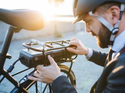 ciclista a colocar bateria na sua bicicleta elétrica