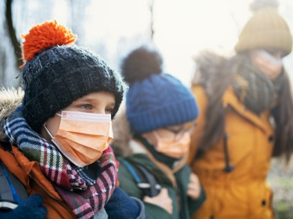 Estudantes agasalhados com casacos, gorros e cachecóis