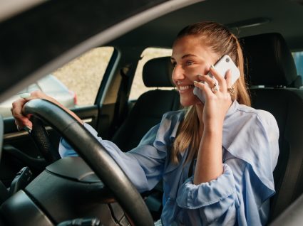 Mulher a falar ao telemóvel enquanto conduz