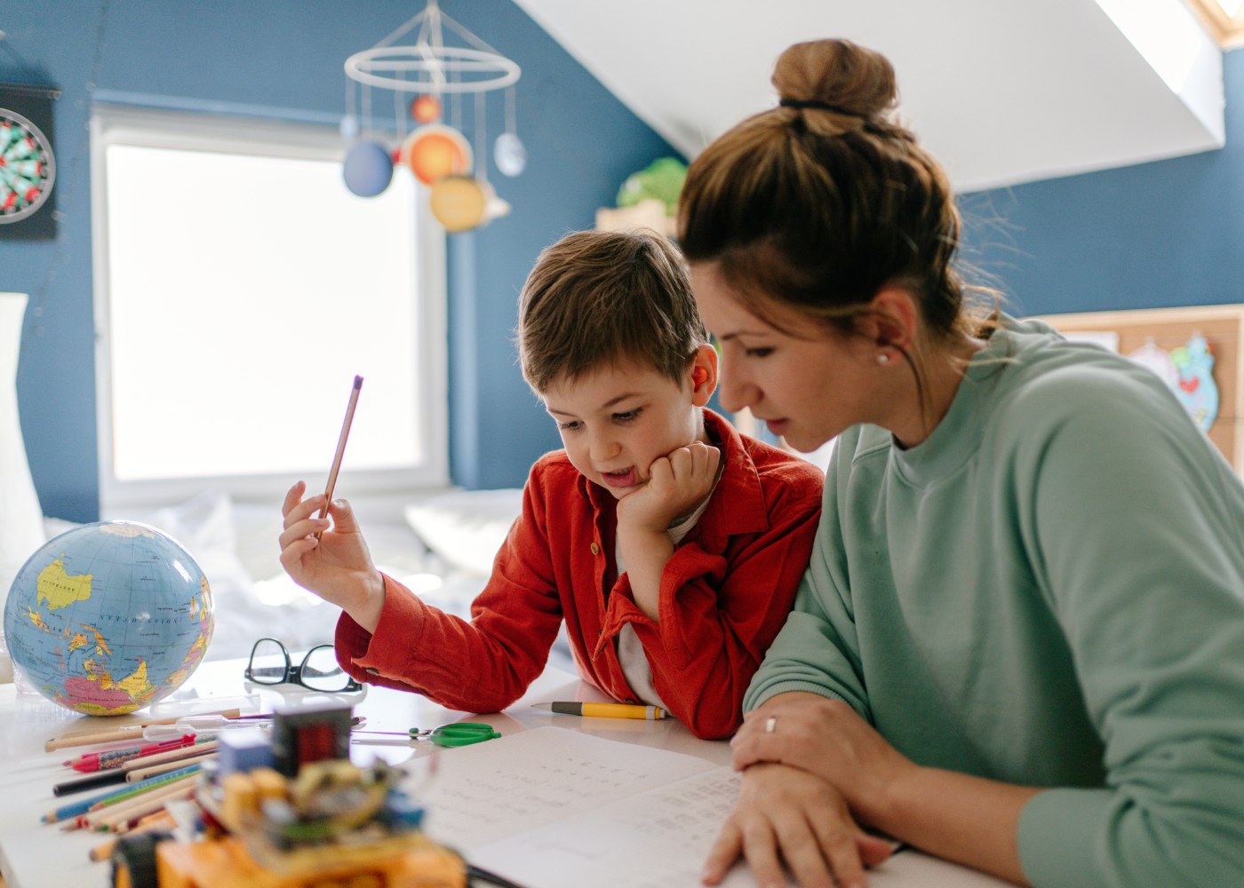 mãe e filho a estudar em casa