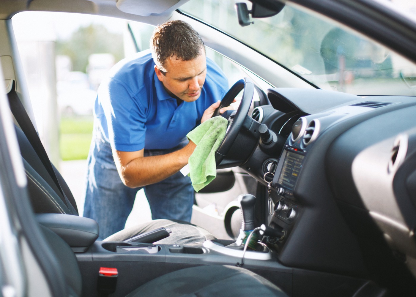 Homem a limpar o interior do carro