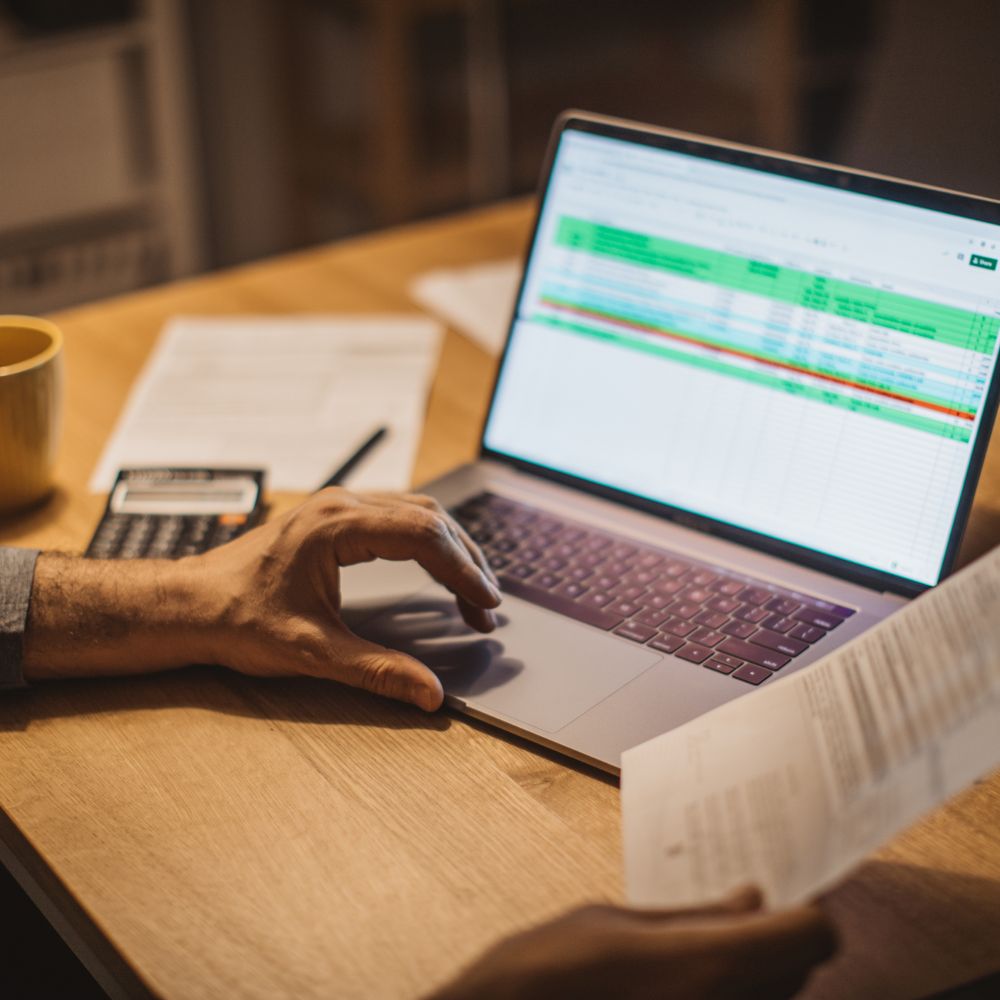 homem ao computador a fazer à prestação do crédito habitação