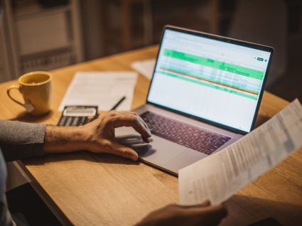 homem ao computador a fazer à prestação do crédito habitação