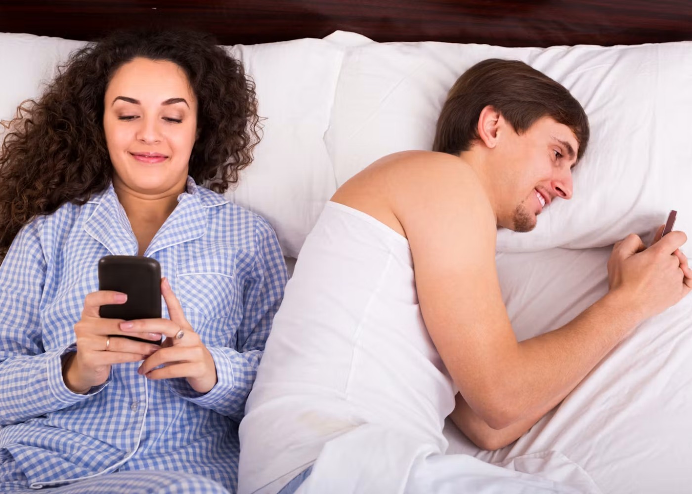casal na cama com telemóveis
