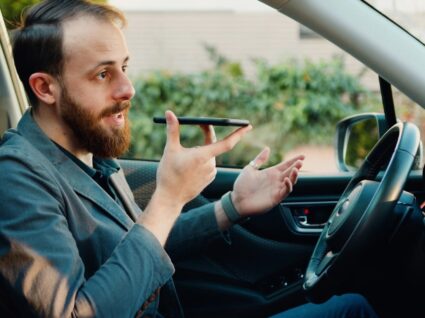 homem com telemóvel no carro